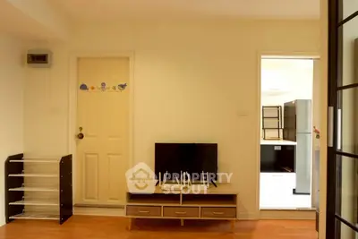 Cozy living room with TV stand and open kitchen view