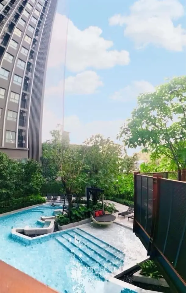 Luxurious high-rise building with stunning pool and lush greenery, perfect for urban living.