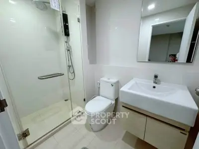 Modern bathroom with glass shower and sleek vanity in a contemporary home.