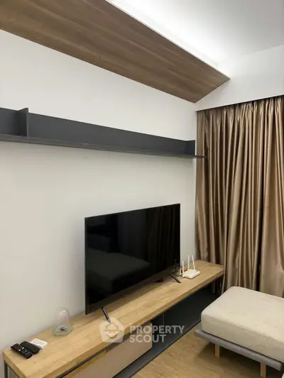 Modern living room with sleek TV setup and elegant curtains