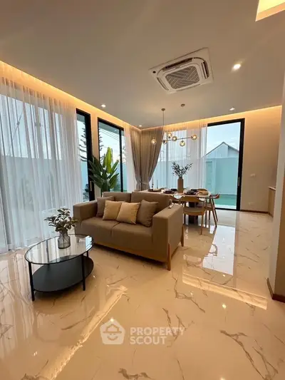 Luxurious modern living room with elegant decor and large windows offering natural light.