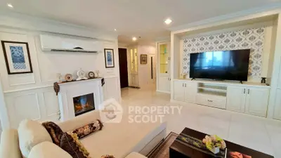 Luxurious living room with elegant decor, fireplace, and large TV in a modern apartment.
