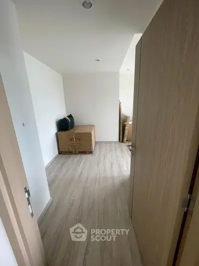 Spacious room with wooden flooring and minimalistic design, perfect for customization.