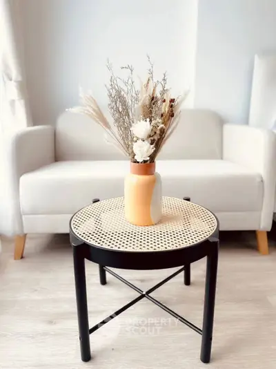 Stylish living room with modern furniture and elegant decor, featuring a cozy white sofa and chic round table.