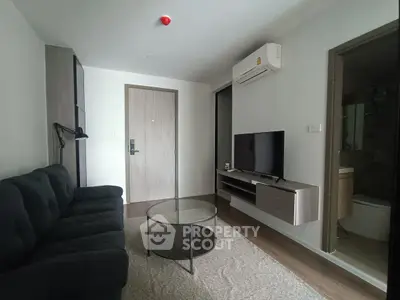 Modern living room with sleek furniture and wall-mounted TV in a cozy apartment.