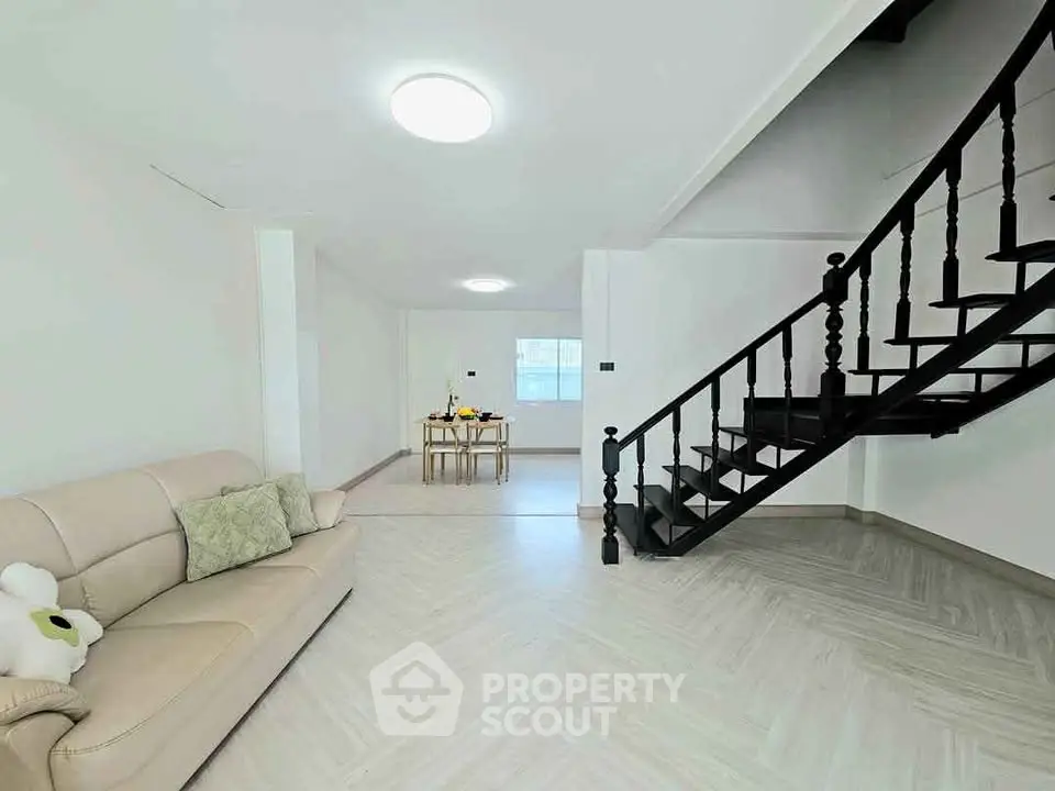 Spacious modern living room with elegant staircase and cozy seating area