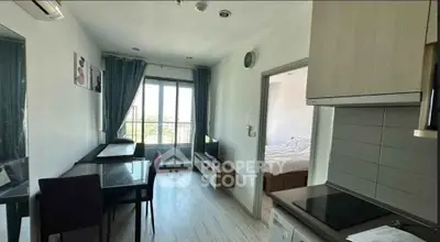 Modern apartment interior with open kitchen and dining area, featuring a bright window view.