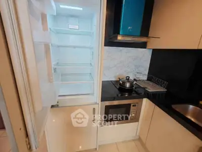 Modern kitchen with open fridge and sleek appliances in compact layout