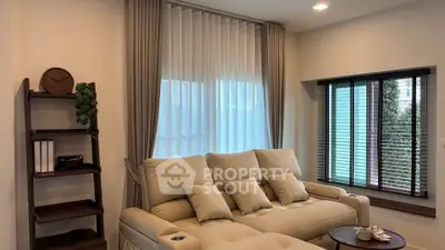 Cozy living room with plush sofa and elegant curtains, perfect for relaxation.