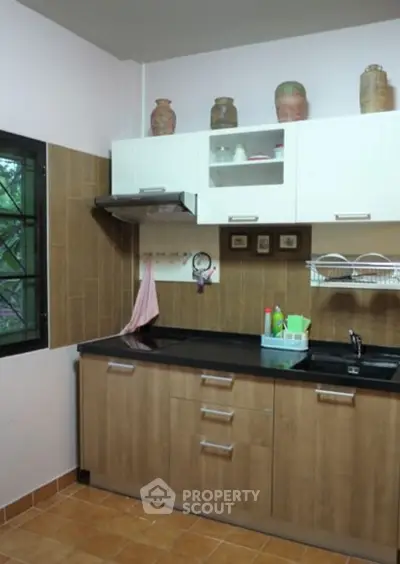 Charming kitchen with wooden cabinets and modern appliances, perfect for culinary enthusiasts.