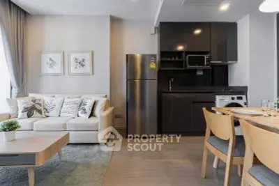 Modern living room with sleek kitchen and cozy dining area in open layout apartment.