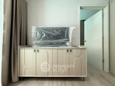 Modern living room with stylish cabinet and TV setup, featuring elegant curtains and sleek flooring.