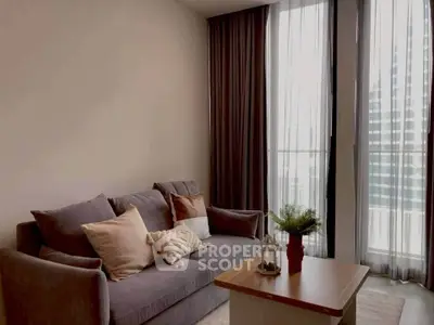 Modern living room with cozy sofa and large windows offering natural light.