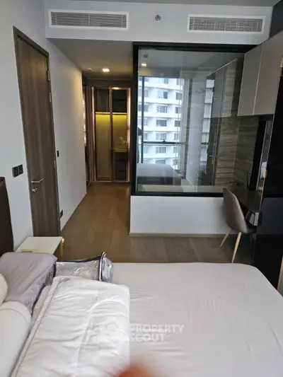 Modern bedroom with glass partition and sleek design in urban apartment