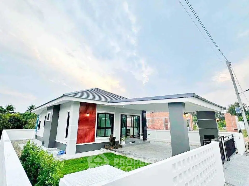 Modern single-story house with sleek design and spacious driveway in a serene neighborhood.