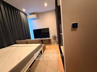 Modern bedroom with stylish decor, featuring a cozy bed, sleek TV setup, and ambient lighting.