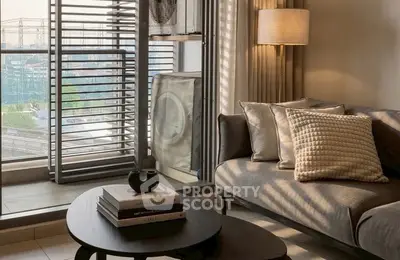 Modern living room with cozy sofa, stylish lamp, and city view through large windows.