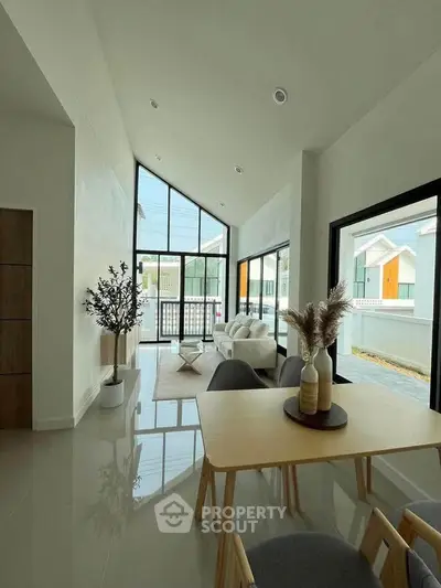 Modern living room with high ceilings and large windows in a stylish home.