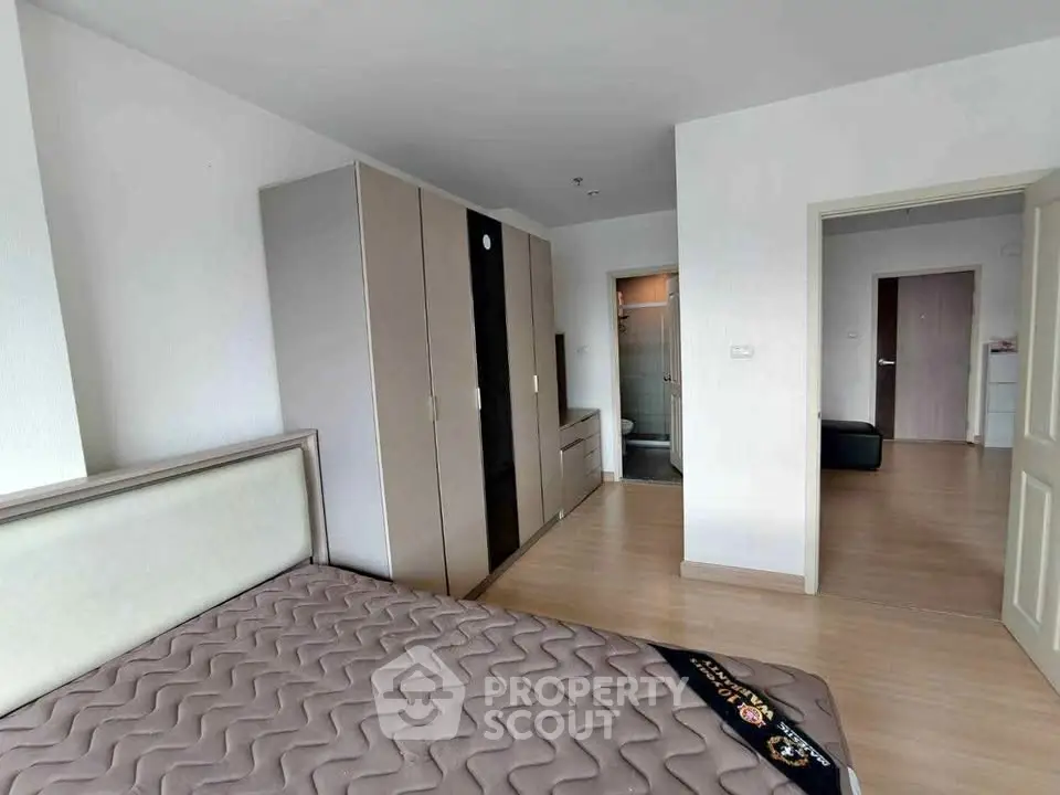 Spacious bedroom with modern wardrobe and ensuite bathroom in a stylish apartment.