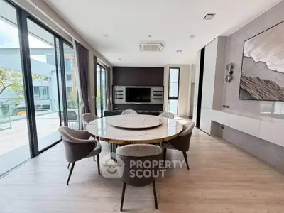 Luxurious modern living room with elegant dining area and large windows offering stunning views.