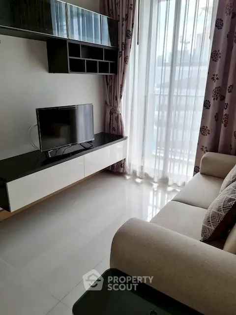 Modern living room with sleek TV setup and large window view.
