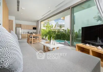 Luxurious open-plan living room with pool view and modern kitchen in tropical villa.