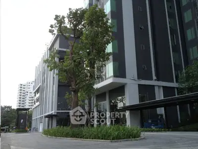 Modern high-rise building exterior with lush greenery and sleek design