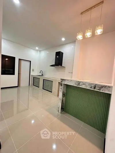 Modern kitchen with sleek design, featuring marble accents and elegant lighting, perfect for contemporary living.