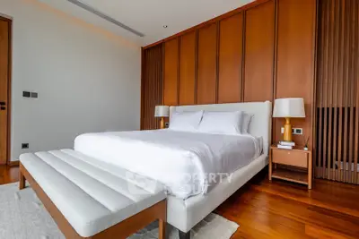 Luxurious modern bedroom with elegant wooden paneling and plush white bedding