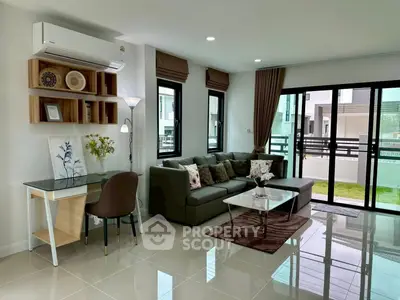 Modern living room with sleek furniture and large windows offering natural light.