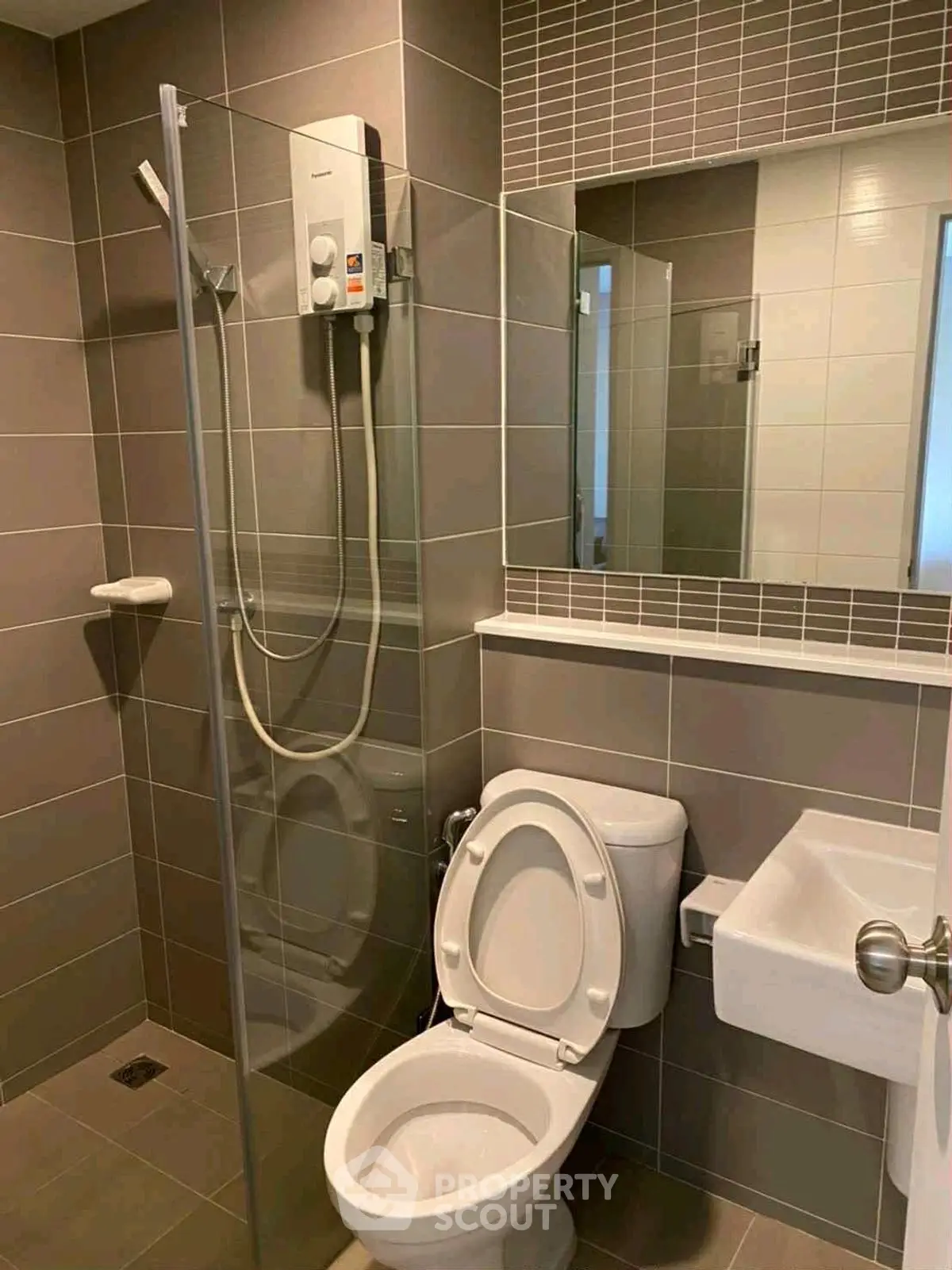Modern bathroom with glass shower and sleek fixtures in contemporary home.