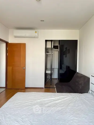 Spacious bedroom with modern closet and air conditioning in a stylish apartment.