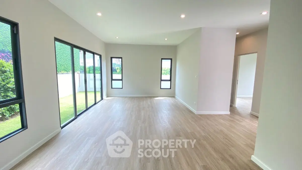 Spacious modern living room with large windows and wooden flooring