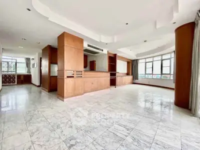 Spacious open-plan living room with marble flooring and large windows