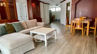 Spacious living room with cozy sofa and elegant dining area, perfect for family gatherings.