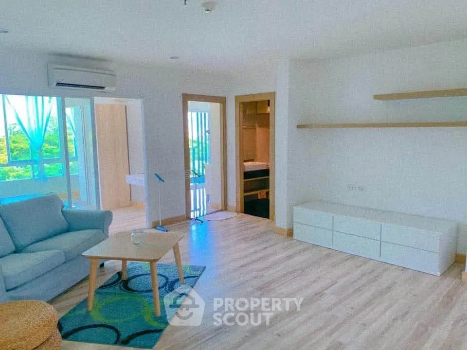 Spacious living room with modern decor and natural light in a stylish apartment.