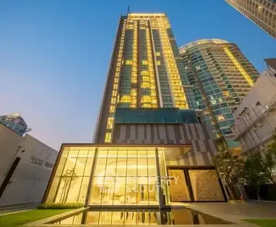 Stunning modern high-rise building with illuminated facade and sleek glass entrance.