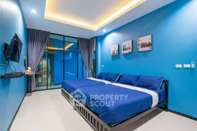 Modern blue-themed bedroom with twin beds and large window view.