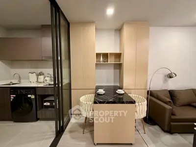 Modern apartment interior with sleek kitchen and cozy living area, featuring stylish furniture and contemporary design.