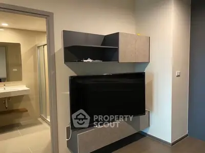Modern living room with sleek TV unit and adjacent bathroom view