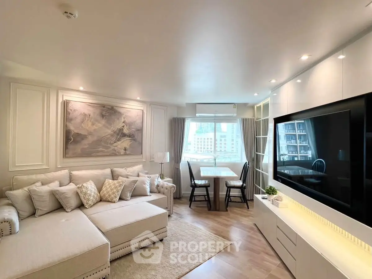 Luxurious living room with modern decor and large TV, perfect for relaxation and entertainment.