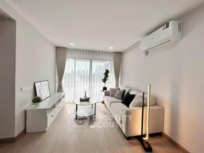 Modern living room with sleek furniture and natural light, featuring a cozy sofa and stylish decor.