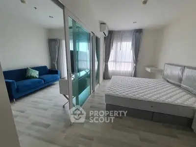 Modern bedroom with glass partition and stylish blue sofa