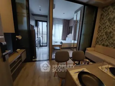 Modern apartment interior with open layout, featuring a cozy living area and stylish bedroom with balcony access.