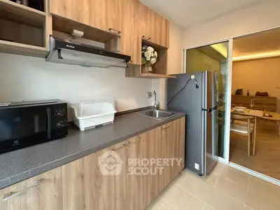 Modern kitchen with wooden cabinets and stainless steel appliances in cozy apartment