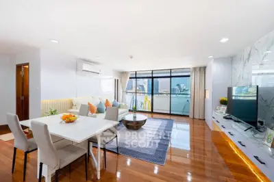 Spacious modern living room with city view, elegant decor, and natural light.