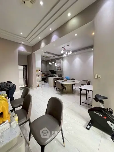Spacious modern dining area with open kitchen and exercise bike, perfect for contemporary living.