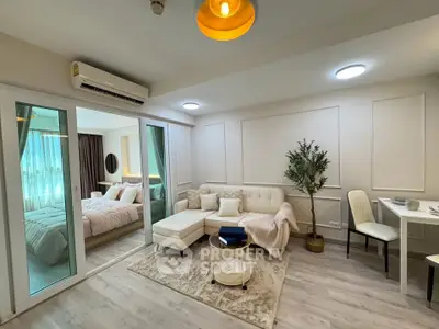 Modern living room with cozy seating and elegant decor adjacent to a stylish bedroom.