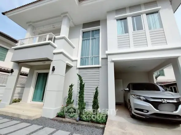 Modern two-story house with attached garage and landscaped front yard.