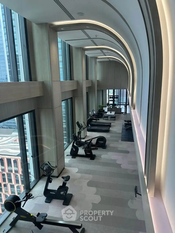 Luxurious high-rise gym with panoramic city views and modern fitness equipment.